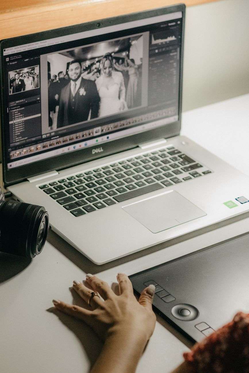 woman hand over laptop with picture of newlyweds on screen