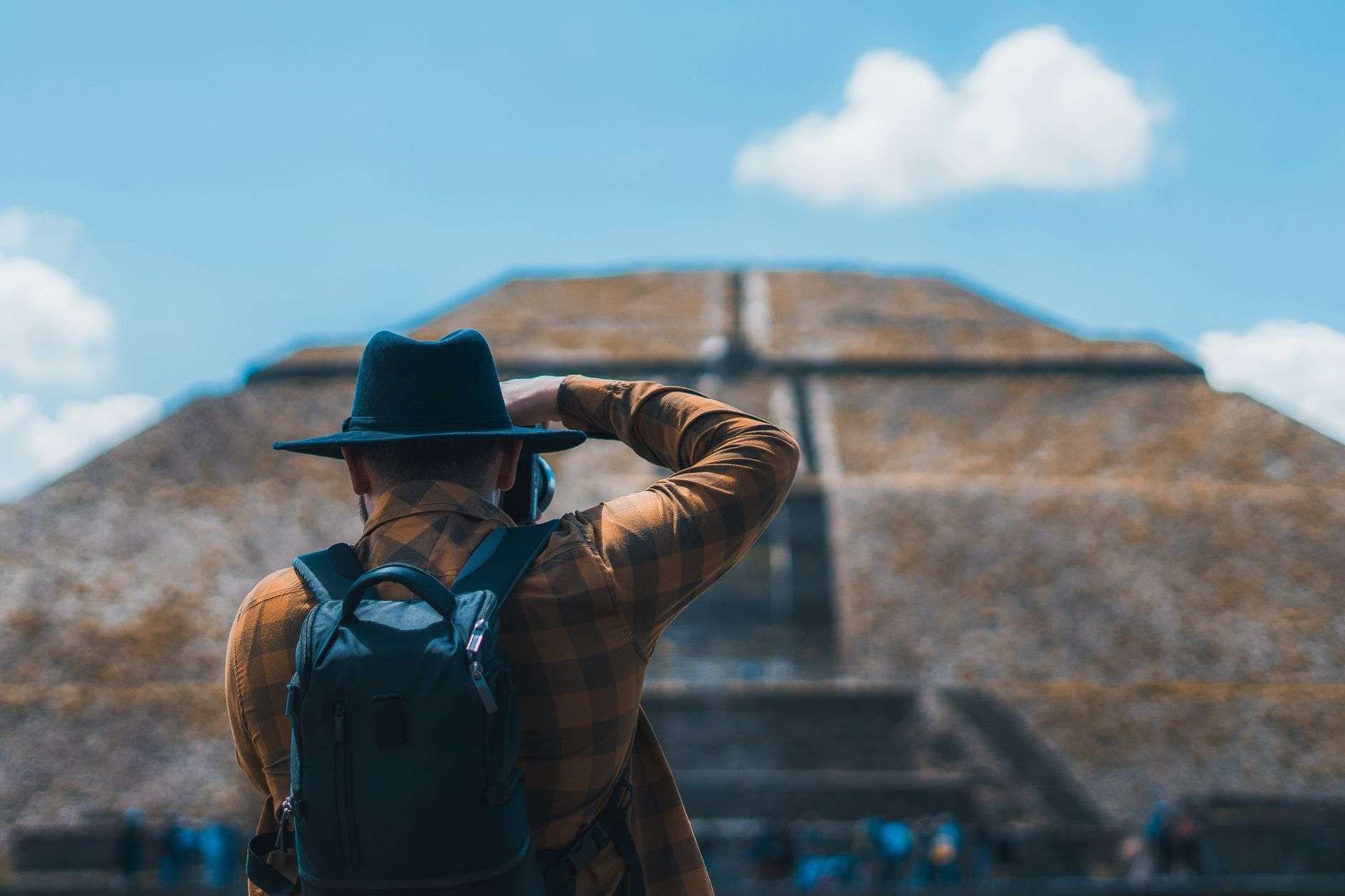 back view of a man photographing a pyramid
