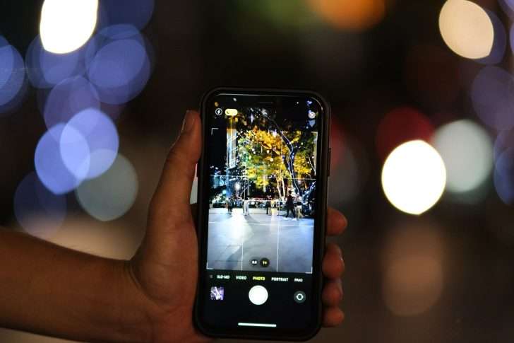 hand holding a smartphone with a displayed photo